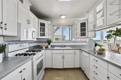 a white kitchen with a stove and a sink at Beachfront 3 Bedroom 3 Bath In Seal Beal, Ca in Seal Beach