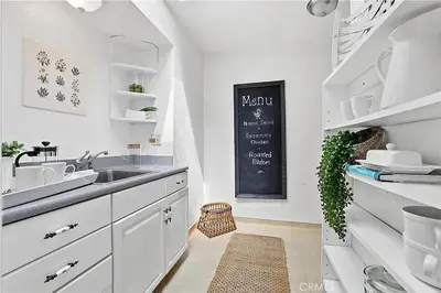 a white kitchen with a sink and a chalkboard at Beachfront 3 Bedroom 3 Bath In Seal Beal, Ca in Seal Beach