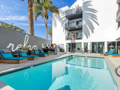 a swimming pool in front of a building with palm trees at Redondo Beach 1BR w Pool Gym nr Beach LAX-398 in Redondo Beach