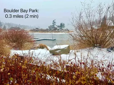 a snowy field with a boat in the water at 1 B1B lake cabin/walk to lake/Boulder bay park in Big Bear Lake
