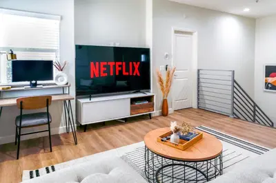 a living room with a television and a table at Cozy Luxe Unit Near Disneyland - Sleeps up to 10! EV Friendly & King Bed in Midway City