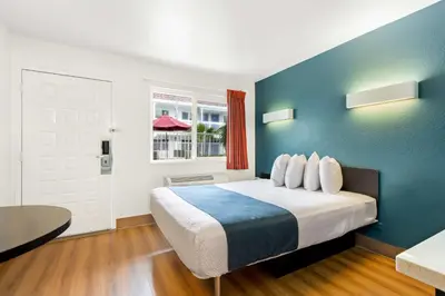 a bedroom with a large bed with a blue wall at Studio 6 Suites Carpinteria, CA Santa Barbara South in Carpinteria