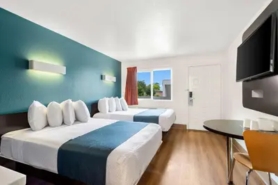 a hotel room with two beds and a flat screen tv at Studio 6 Suites Carpinteria, CA Santa Barbara South in Carpinteria
