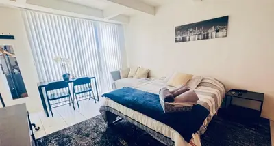 a bedroom with a bed and a table with a chair at Wonderful LA studio apartment in Los Angeles