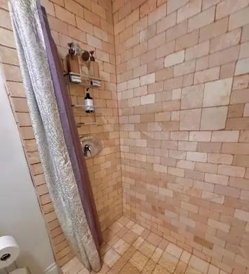 a bathroom with a shower with brown tile at Wonderful LA studio apartment in Los Angeles