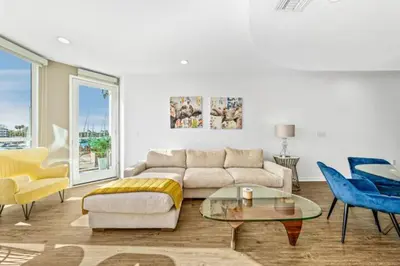 a living room with a couch and a table and chairs at The Coral Loft - Marina Bliss Water view 2BR Pool, Gym in Los Angeles