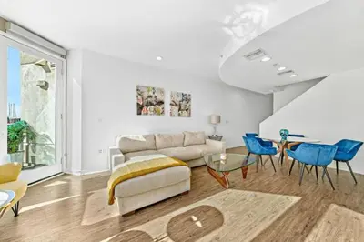 a living room with a couch and blue chairs at The Coral Loft - Marina Bliss Water view 2BR Pool, Gym in Los Angeles
