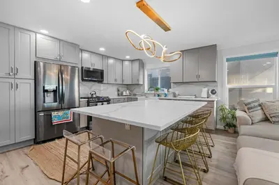 a kitchen with a large island with bar stools at On the Boardwalk in Long Beach