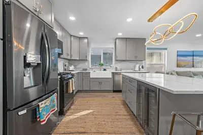 a large kitchen with stainless steel appliances and white cabinets at On the Boardwalk in Long Beach