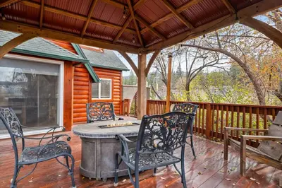 a patio with chairs and a table on a deck at Serene Lakefront Haven by Rather Be Properties in Big Bear Lake