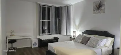 a bedroom with a bed and a chair and a window at Large two-room apartment near LAX and the Ocean in Los Angeles