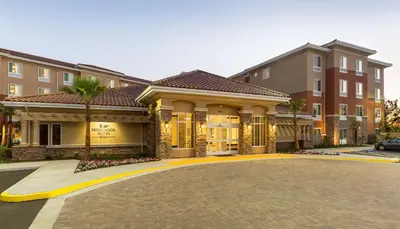 a large building with a driveway in front of it at Homewood Suites by Hilton San Bernardino in San Bernardino