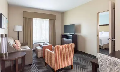a hotel suite with a living room with a television at Homewood Suites by Hilton San Bernardino in San Bernardino