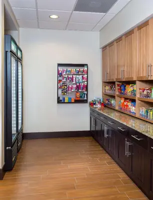 a pharmacy aisle with wooden cabinets and shelves at Homewood Suites by Hilton San Bernardino in San Bernardino