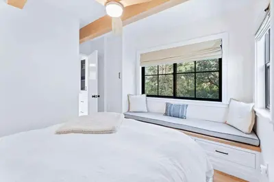 a white bedroom with a window seat and a bed at Majestic Lakeview Lodge in Lake Arrowhead