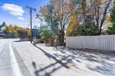 an empty street with a fence and a house at Majestic Lakeview Lodge in Lake Arrowhead