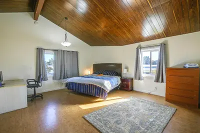 a bedroom with a bed and a desk and windows at Lakewood Home about 5 Mi to Knotts Berry Farm! in Lakewood