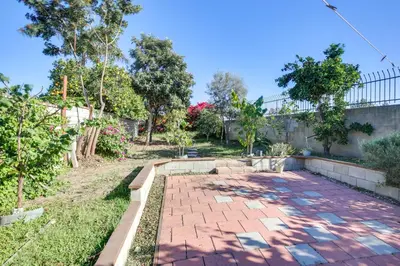a brick walkway in a yard with trees at Lakewood Home about 5 Mi to Knotts Berry Farm! in Lakewood