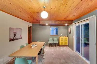 a dining room with a wooden ceiling and a table and chairs at Crestline Cabin Mountain Views and Fire Pit! in Crestline