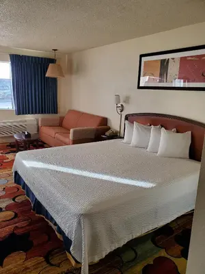 a hotel room with a large bed and a couch at Eunice Plaza Motel in El Monte