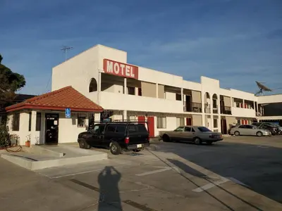 a hotel with cars parked in a parking lot at Eunice Plaza Motel in El Monte