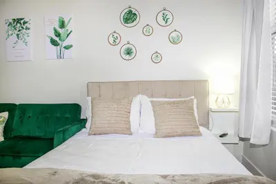 a bedroom with a bed and a green couch at MDR Studio Apartment Luxury pool, gym, parking, jacuzzi. in Los Angeles