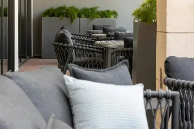 a row of tables and chairs with pillows on a patio at TownePlace Suites by Marriott Monrovia in Monrovia