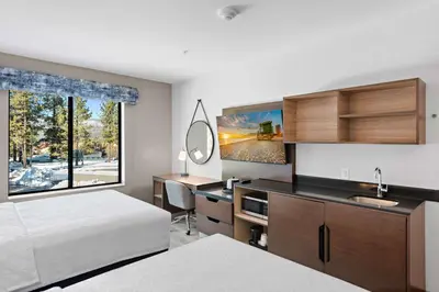 a bedroom with a bed and a desk with a mirror at Hampton Inn Big Bear Lake in Big Bear Lake