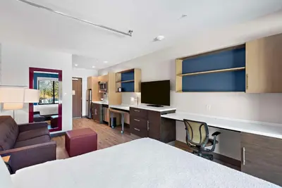a hotel room with a bed and a living room at Home2 Suites By Hilton Big Bear Lake in Big Bear Lake