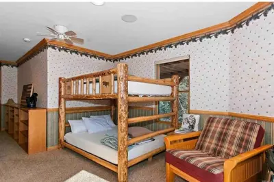 a bedroom with a bunk bed and a chair at Peaceful Cabin Home with Breathtaking View! in Big Bear City