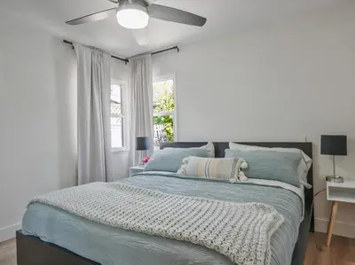 a bedroom with a bed with a ceiling fan at Hollywood Dream pool home & king beds in Los Angeles
