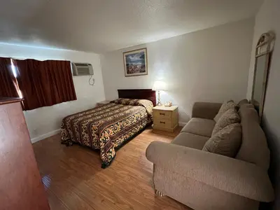 a hotel room with a bed and a couch at Sherwood Motel in Palmdale