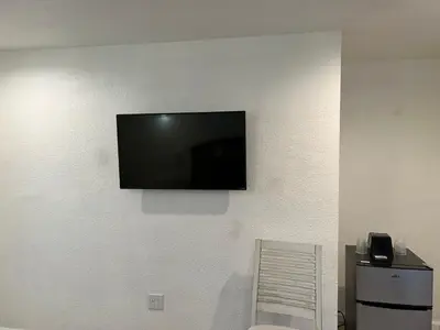 a flat screen tv hanging on a wall at Sherwood Motel in Palmdale