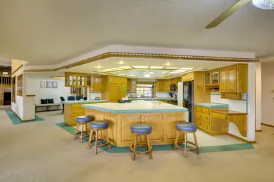 a kitchen with a large island with bar stools at Spacious California Oasis Patio, Fireplace and Pool in Apple Valley