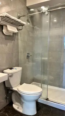 a bathroom with a toilet and a glass shower at Budget inn Whittier in Whittier