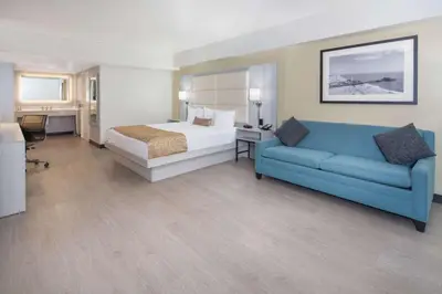 a hotel room with a bed and a couch at Ramada by Wyndham Burbank Airport in Burbank
