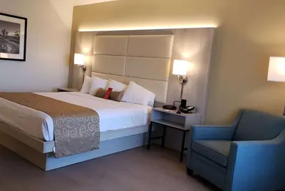 a hotel room with a bed and a chair at Ramada by Wyndham Burbank Airport in Burbank