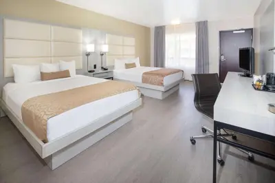 a hotel room with two beds and a television at Ramada by Wyndham Burbank Airport in Burbank