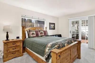 a bedroom with a bed and a dresser and a window at Divine Chateau Big Bear~ Hot Tub~ Walk to Lake~ in Big Bear Lake