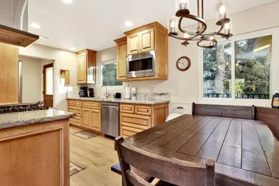 a large kitchen with a wooden table and a dining room at A Hidden Asset Big Bear~ Hot Tub~ Walk to Village~ in Big Bear Lake