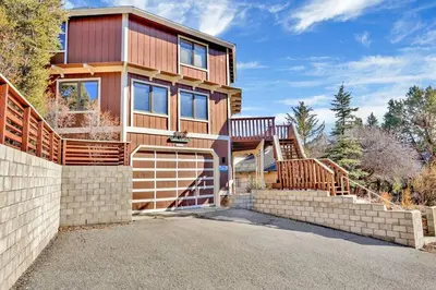 a house with a garage and a fence at The Octagon Big Bear~ Hot Tub~ Pool Table~Views in Big Bear City