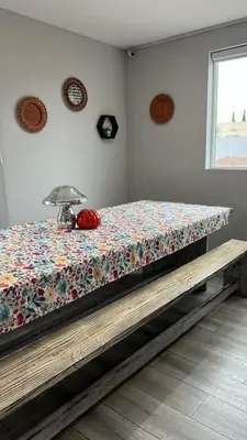 a bed in a room with a table with a flowered blanket at Normandie Hostel in Los Angeles
