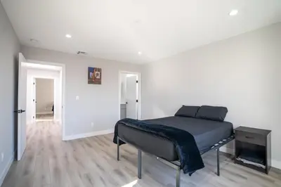 a bedroom with a bed in a white room at Normandie Hostel in Los Angeles
