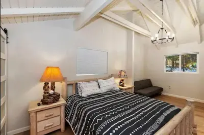 a bedroom with a large bed and a couch at Modern Moab: Near Boulder Bay + Spa + Large Yard in Big Bear Lake