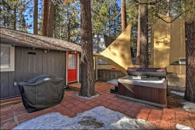 a backyard with a patio with a house and trees at Modern Moab: Near Boulder Bay + Spa + Large Yard in Big Bear Lake