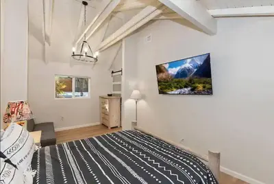 a bedroom with a bed and a tv on the wall at Modern Moab: Near Boulder Bay + Spa + Large Yard in Big Bear Lake