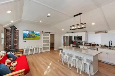 a kitchen and living room with a red couch at Modern Moab: Near Boulder Bay + Spa + Large Yard in Big Bear Lake