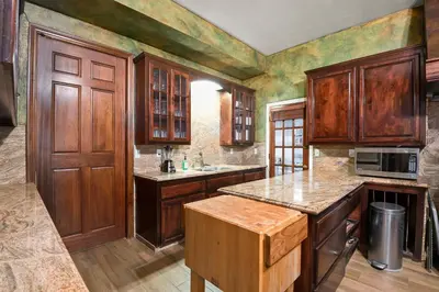a kitchen with wooden cabinets and a counter top at Mountain High Luxury Castle &Spa in Wrightwood