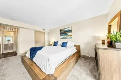 a bedroom with a large bed with blue pillows at The Moonstone - Cozy Marina side Garden View Pool and Gym in Los Angeles