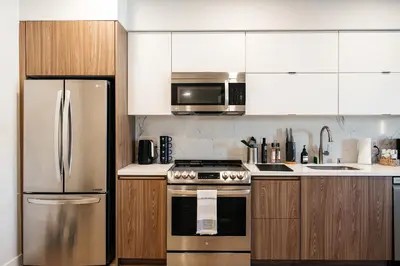 a kitchen with stainless steel appliances and wooden cabinets at Elegant Apartment in the Heart of Hollywood in Los Angeles